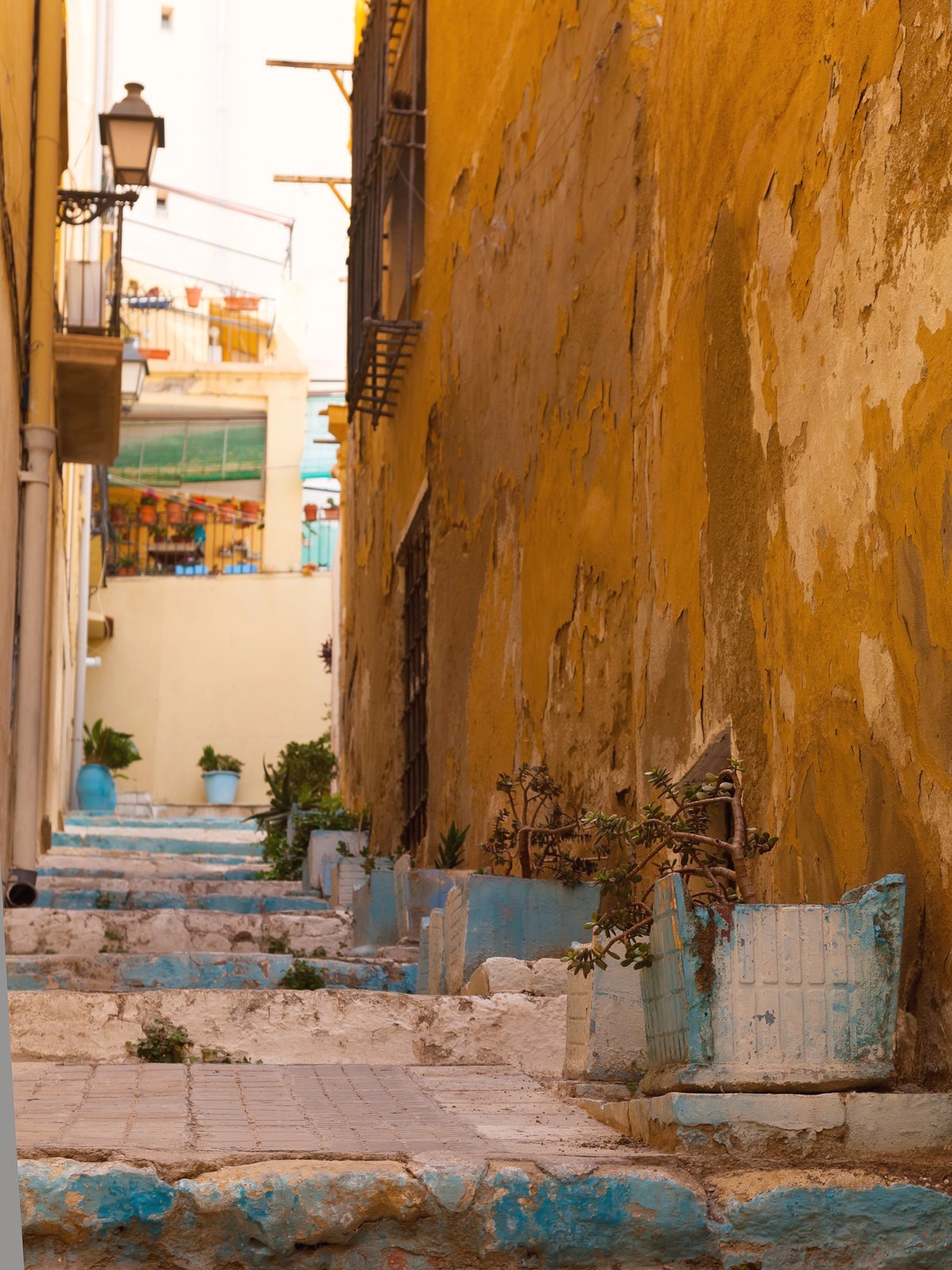Calle del casco antiguo de Alicante, con escaleras y fachadas ocre
