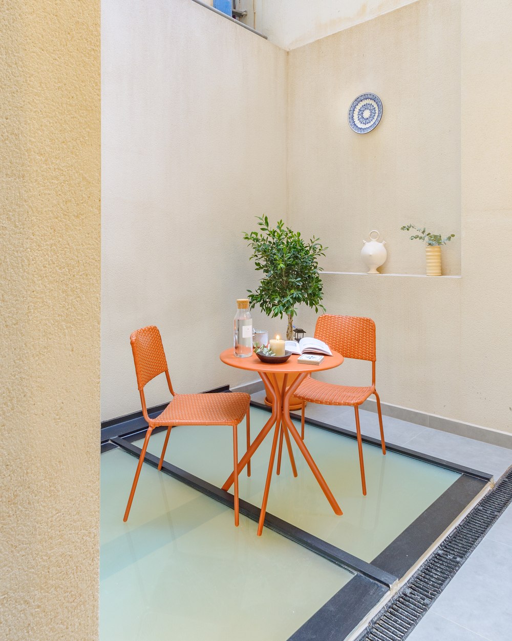 Alma House inner courtyard with orange chairs and overhead light