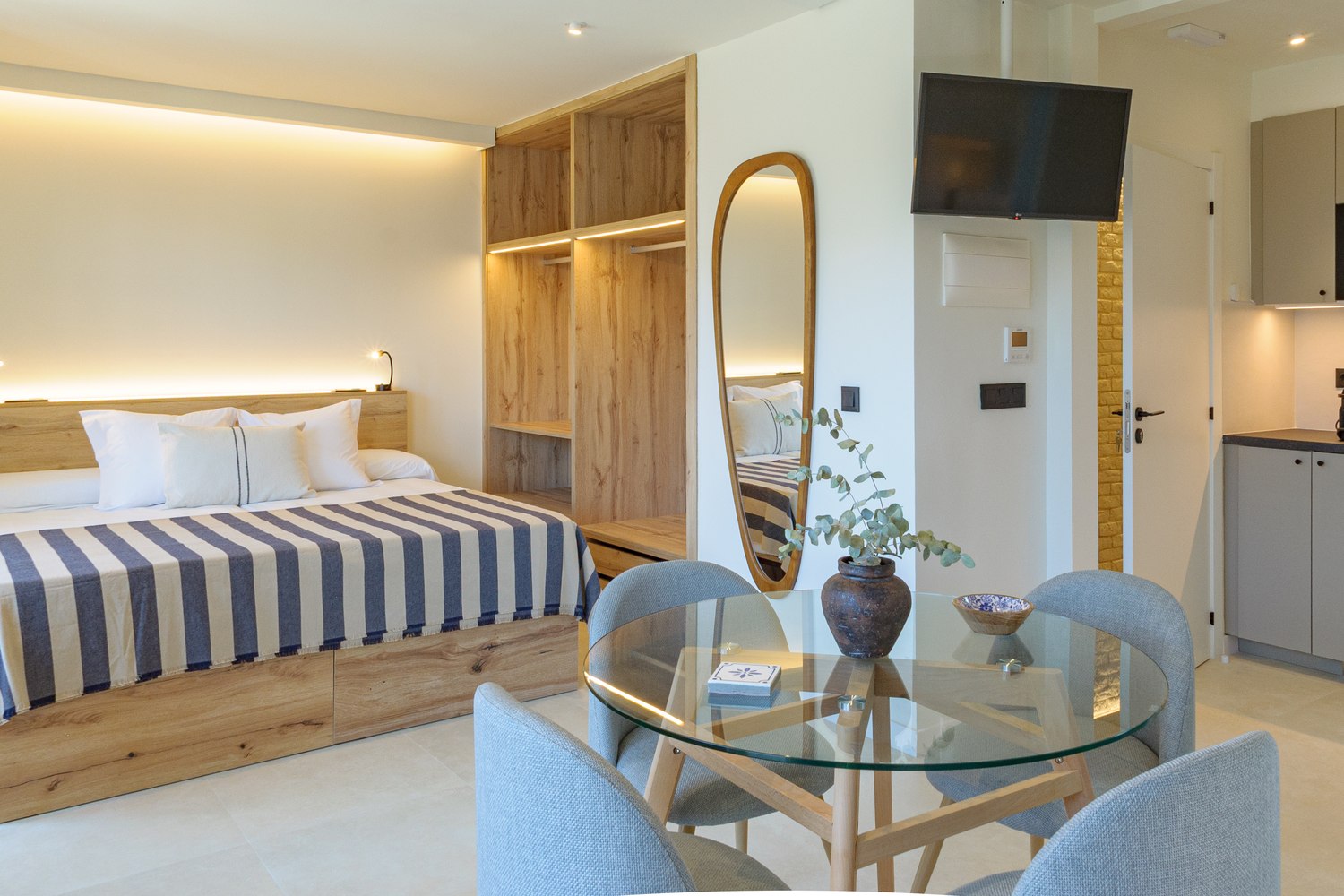 Alma House suite with striped bedding, wooden headboard and integrated kitchen