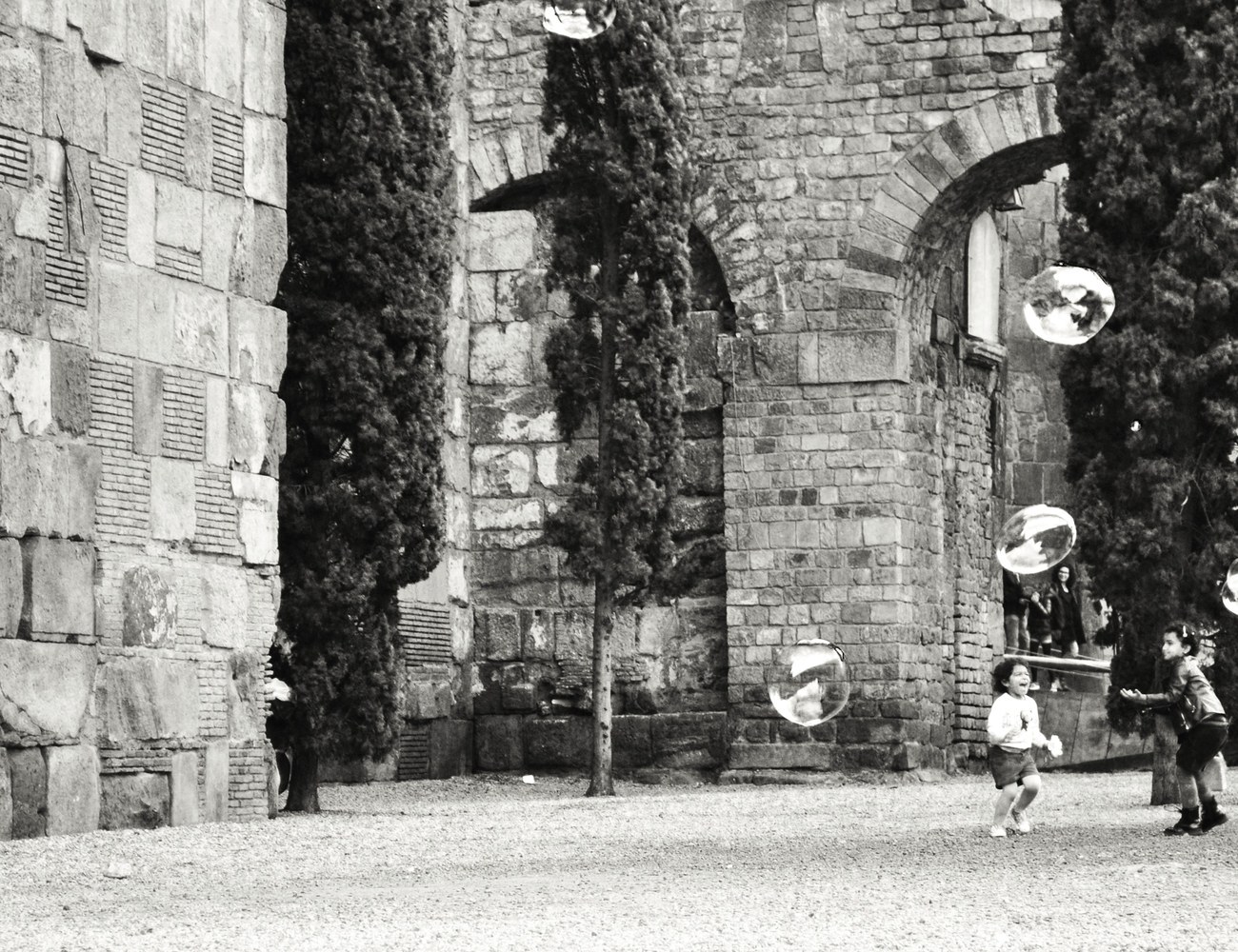 Niños jugando con pompas junto a las murallas, Barcelona