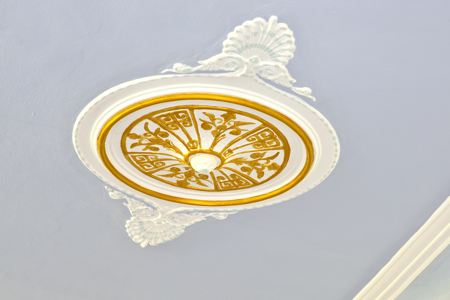 Rosetón modernista dorado del techo, Hostal Girona