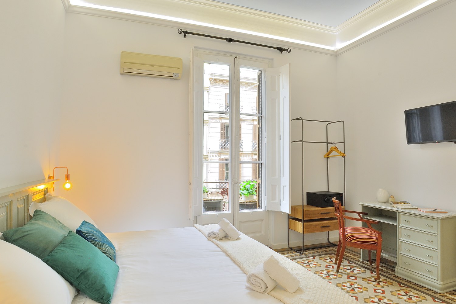 Dormitorio luminoso con cojines verdes, Hostal Girona