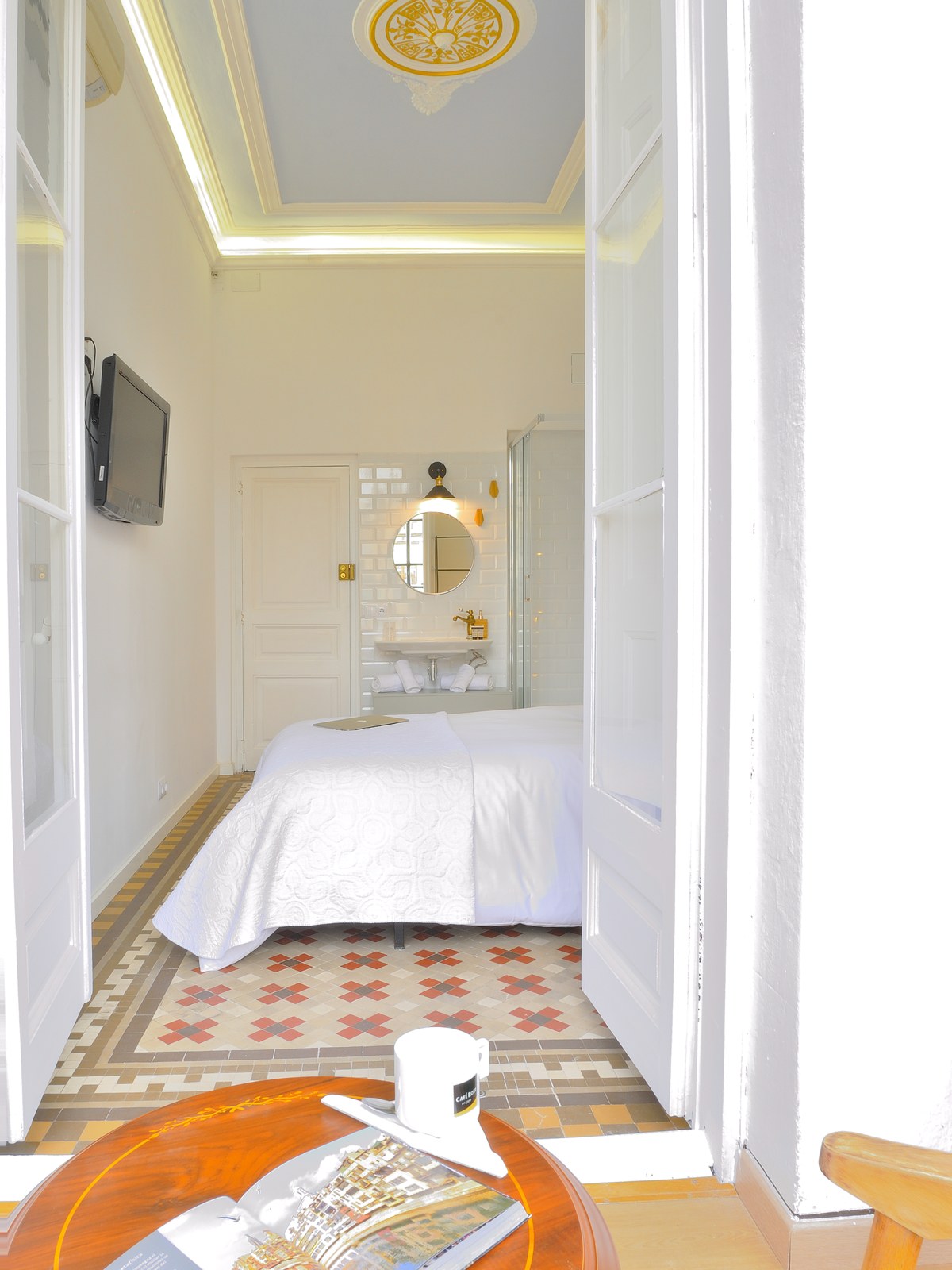 Dormitorio con techo azul, rosetón dorado y suelo hidráulico, Hostal Girona